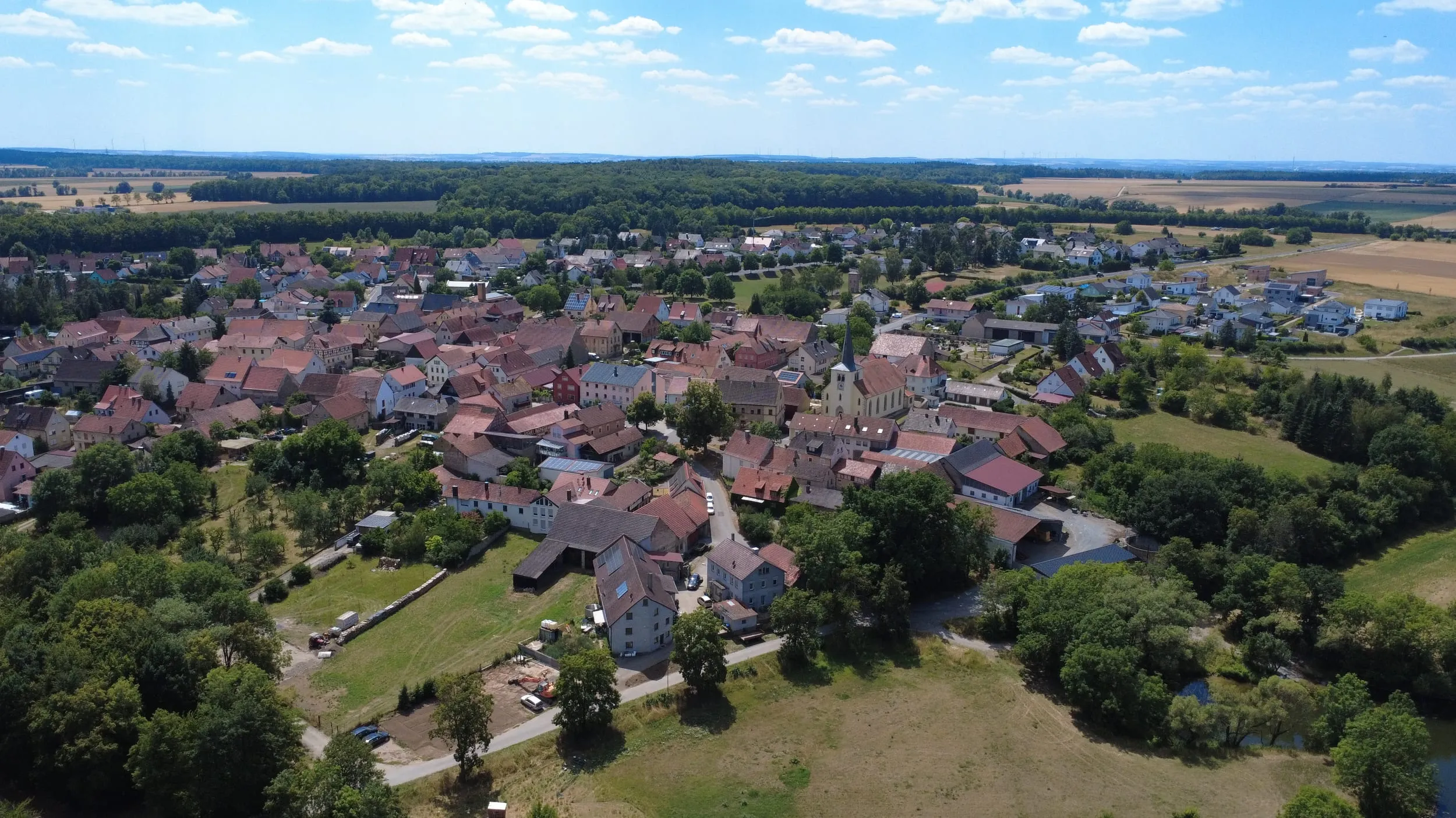 Luftbild von Untereuerheim zwischen Feldern und Waldrand.