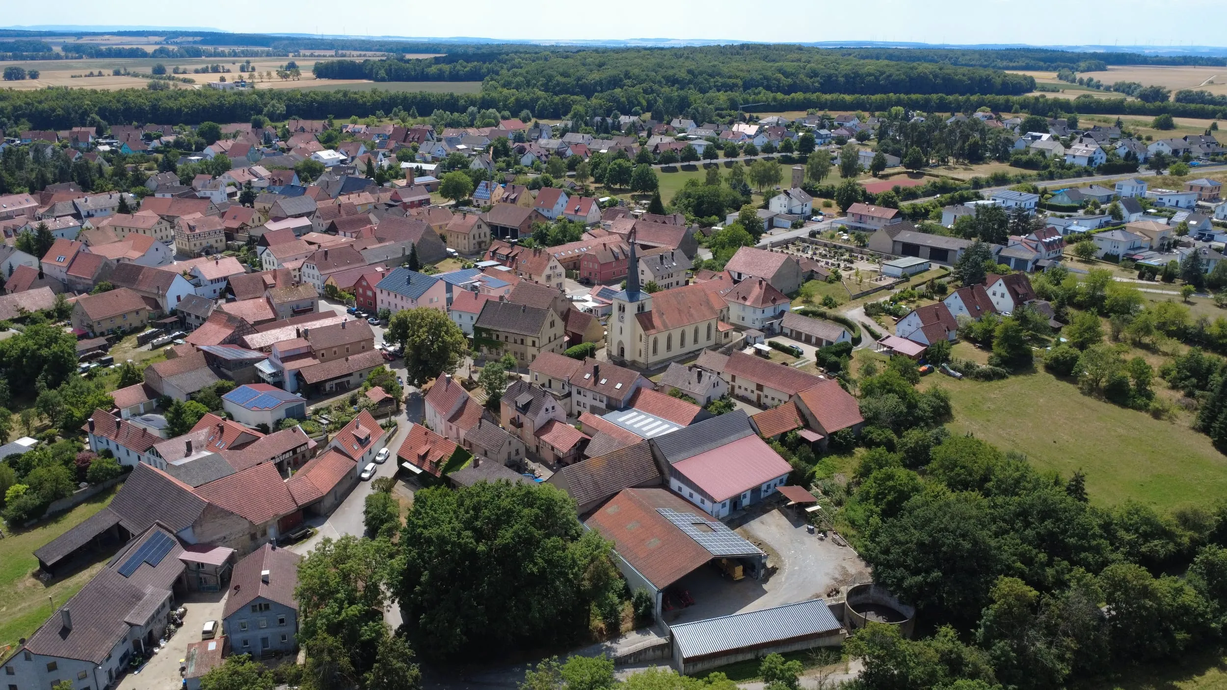 Luftaufnahme der dicht bebauten Ortsmitte von Untereuerheim mit der Pfarrkirche St. Gallus im Zentrum.