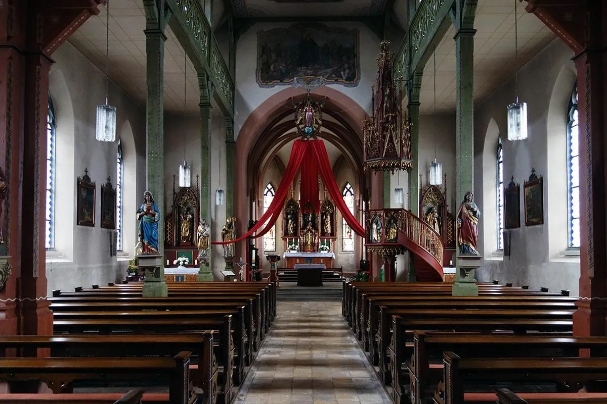 Innenraum der Pfarrkirche St. Gallus mit Hauptaltar, Seitenaltären und Kanzel.